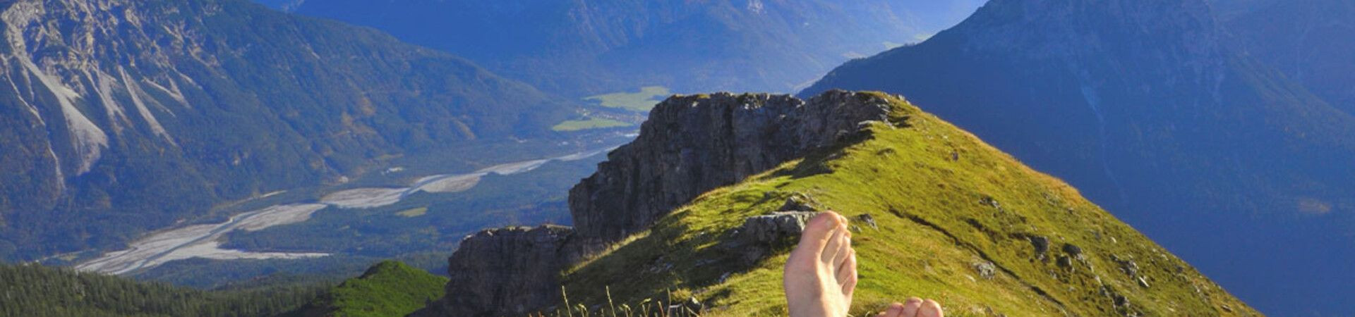 Pausa a piedi nudi su una cresta davanti alle vette - Alpi