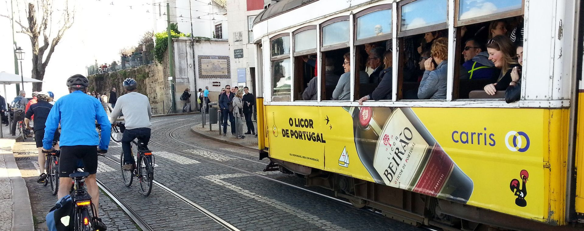 Ciclisti e tram giallo in città - Lisbona - Portogallo