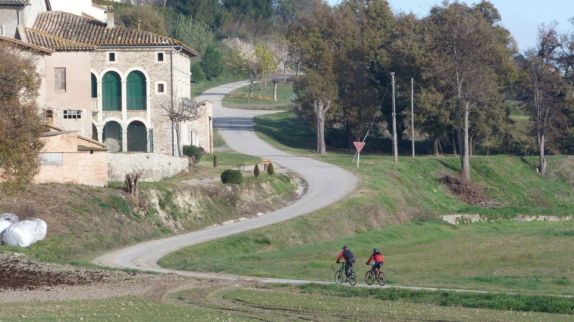 Ciclisti su una strada di campagna vicino a un casale - tra Vic e Barcellona - Catalogna - Spagna