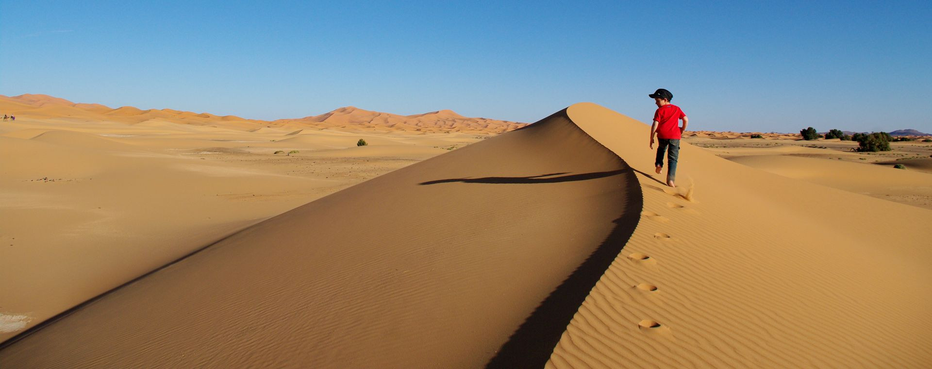 Bambino tra le dune del deserto del Marocco meridionale