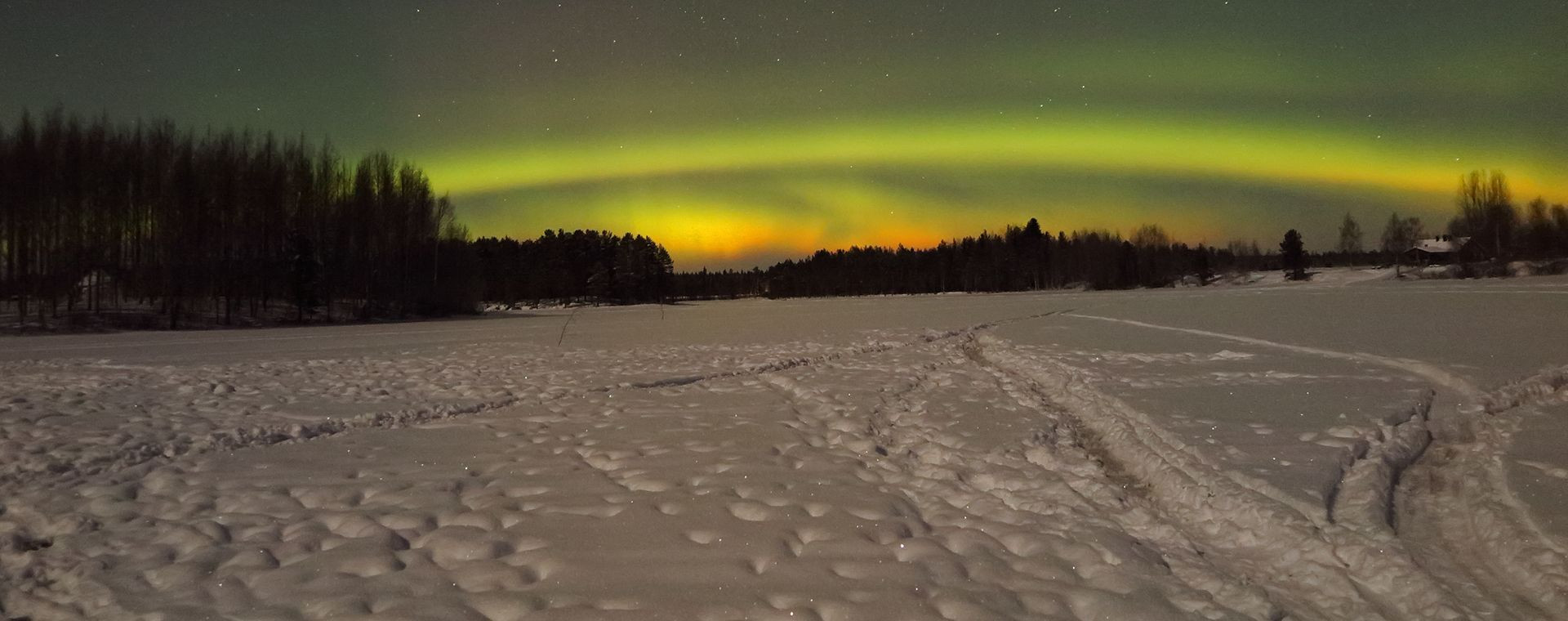 Aurora boreale su un lago ghiacciato e innevato - Lapponia - Finlandia