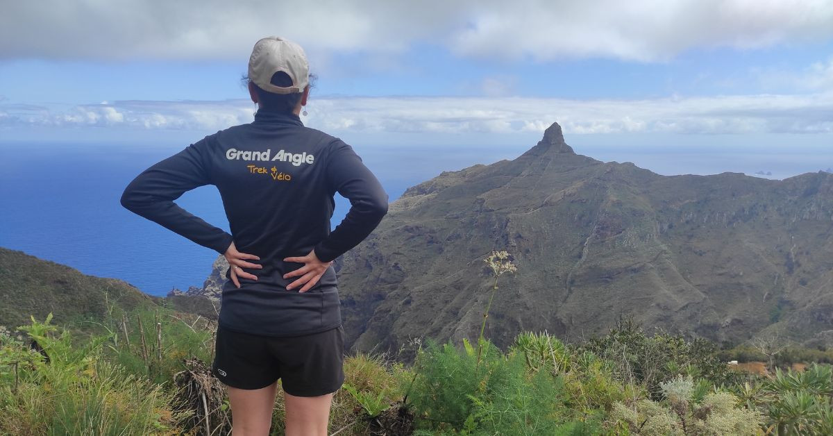 Escursionista di fronte alle montagne vulcaniche e all’oceano - Tenerife - Canarie