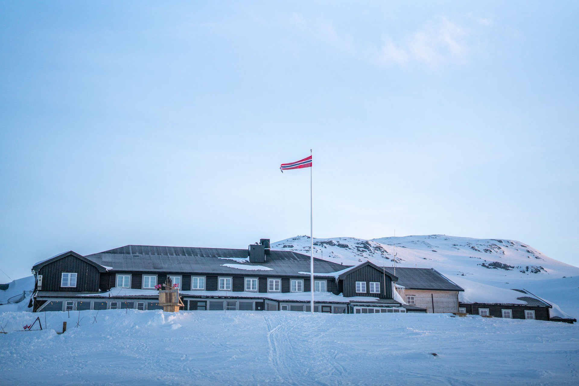 Rifugio di montagna con bandiera norvegese sotto la neve - Norvegia