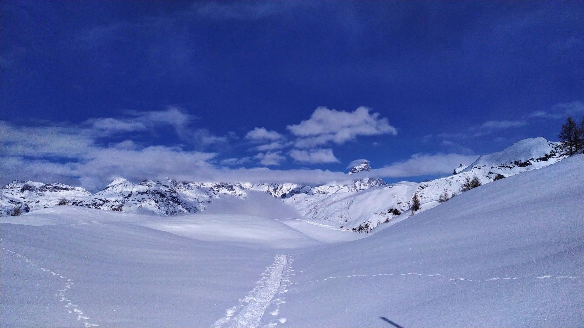 Trace de ski sur un plateau enneigé vers les sommets - Alpes