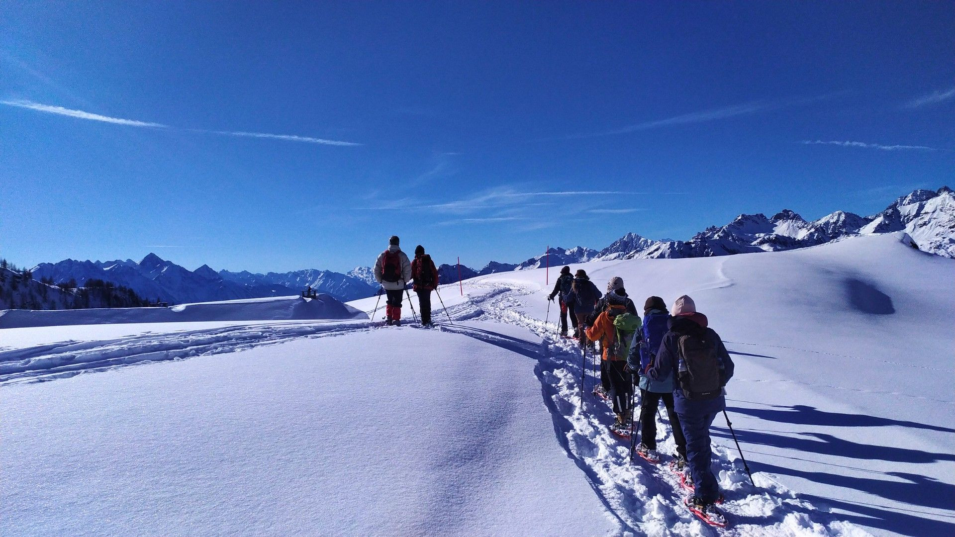 Groupe en raquettes sur une crête enneigée - Alpes