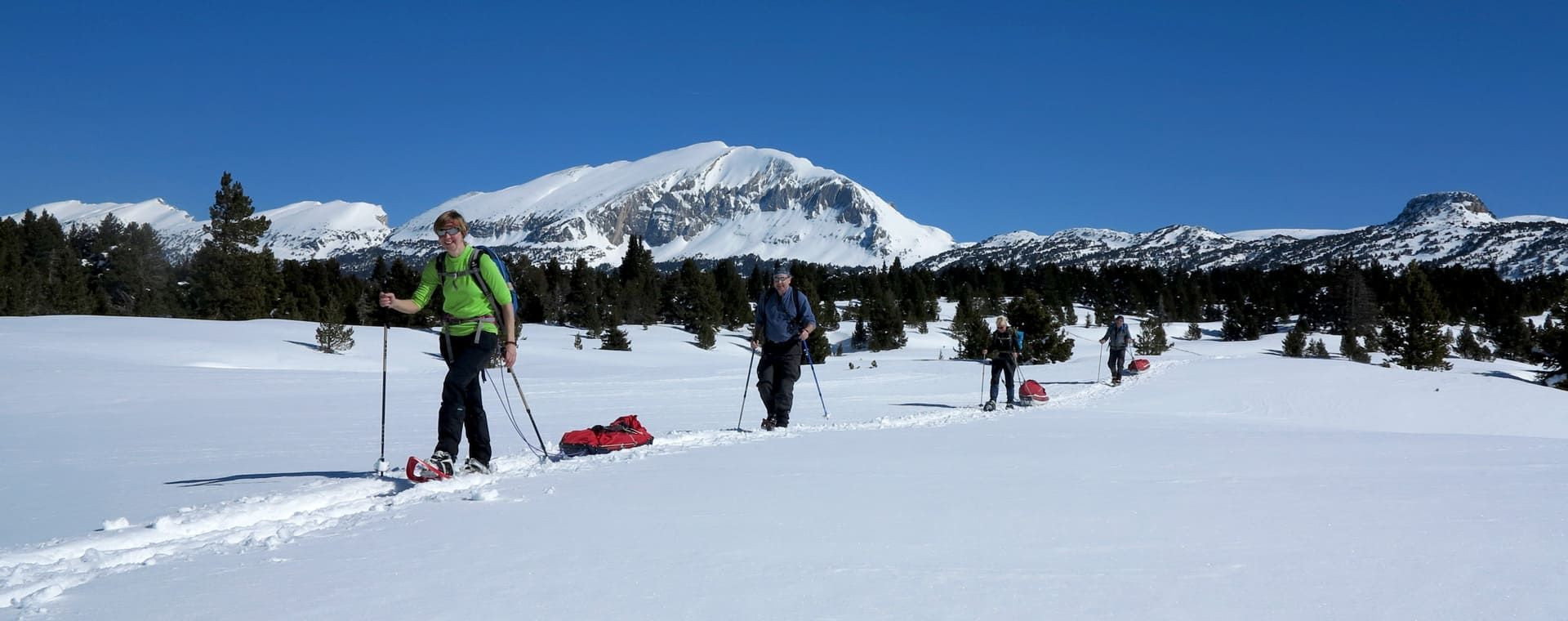 Escursionisti con le racchette da neve e pulka davanti al Grand Veymont - altopiani del Vercors - Francia