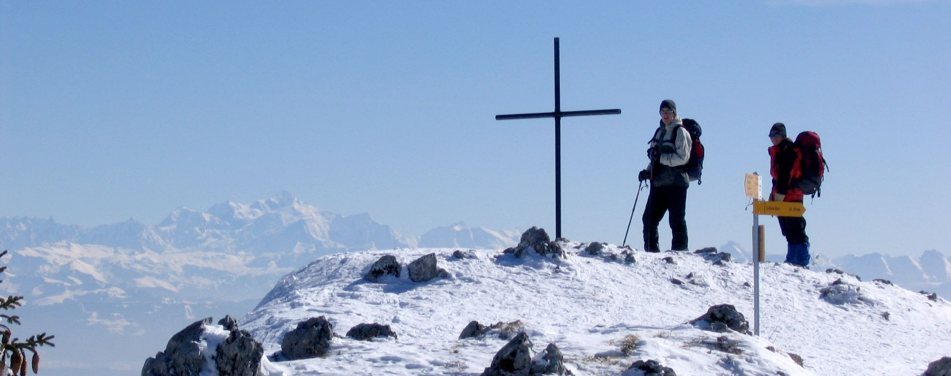 Escursionisti con le ciaspole vicino a una croce di vetta - Giura franco-svizzero