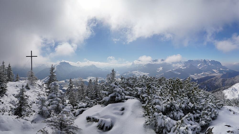 Croce di vetta innevata e panorama alpino - Alpi