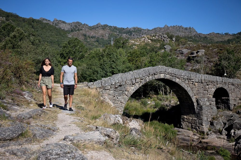 © Authentic Trails Escursionisti vicino a un ponte di pietra - Parco nazionale di Peneda-Gerês - Portogallo